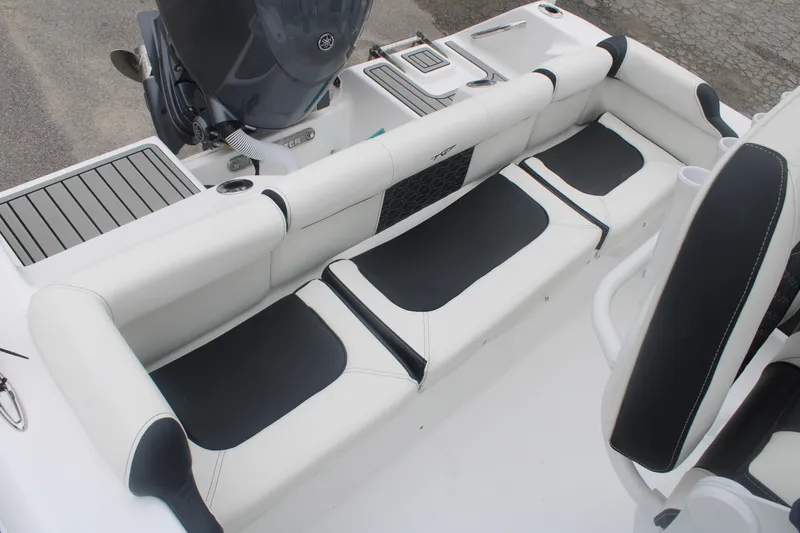 Slide: The Image of 2026 Tidewater 210 LXF boat interior with cushioned seating and motor detail. - 13