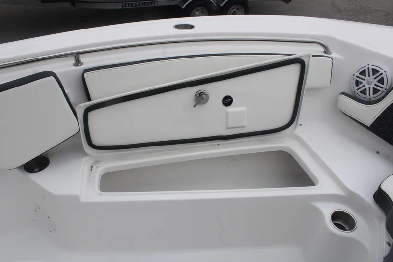 Slide: The Image of 2026 Tidewater 210 LXF boat interior storage compartment with speaker and cup holder. - 18