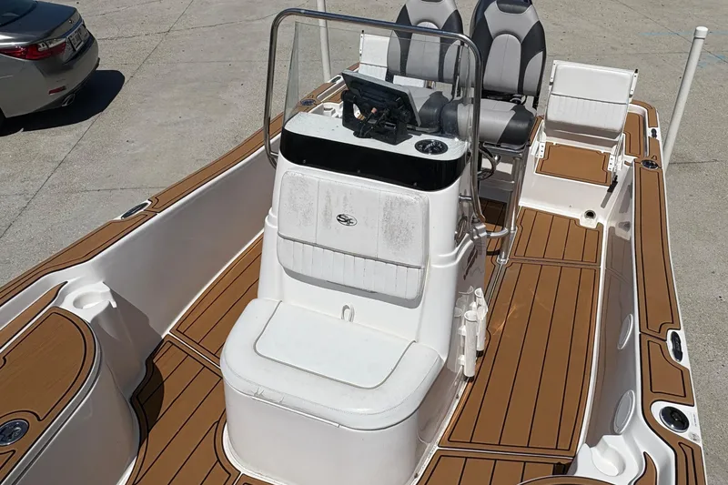 Slide: The Image of 2014 Seafox 180 Viper boat interior with seating and console, docked on concrete surface. - 11