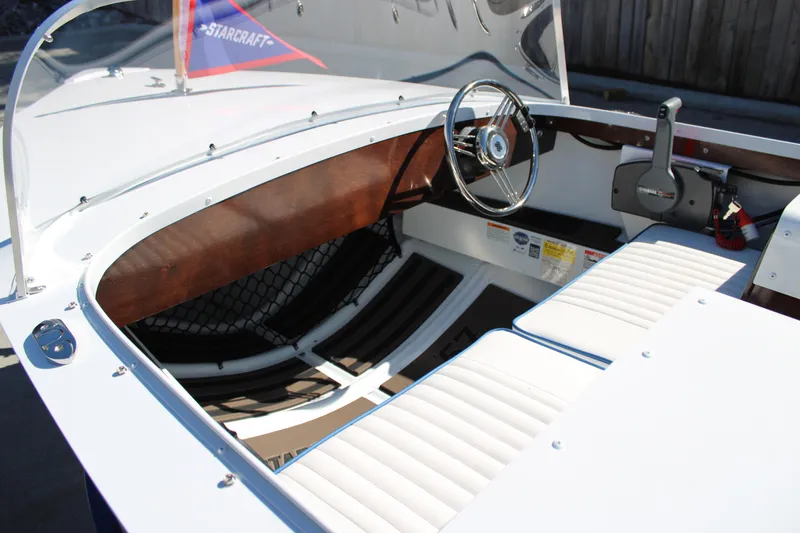Slide: The Image of 2026 Starcraft 57 Ski Champ boat interior with steering wheel and seating. - 12