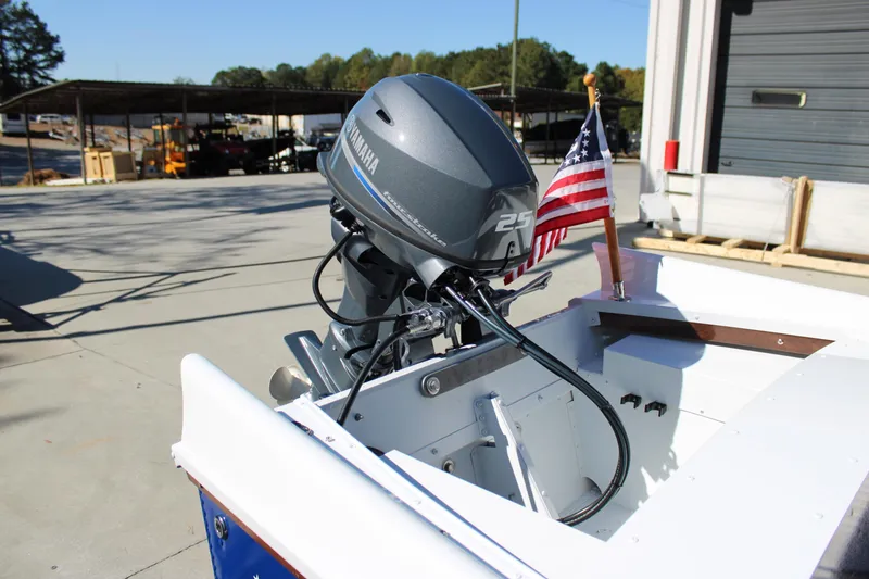 Slide: The Image of 2026 Starcraft 57 Ski Champ boat with Yamaha 25 outboard motor and American flag. - 9