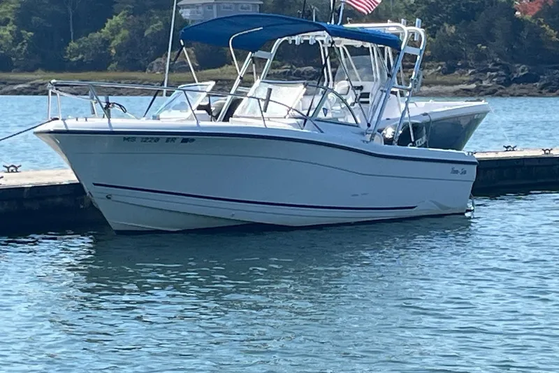 Slide: The Image of 2003 Palm Beach 22 Dual Console boat docked on calm water. - 2