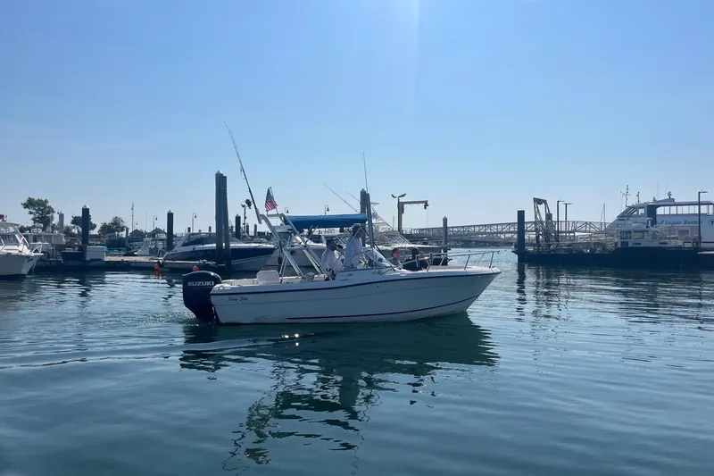 Slide: The Image of 2003 Palm Beach 22 Dual Console boat cruising in a marina with clear blue skies. - 3