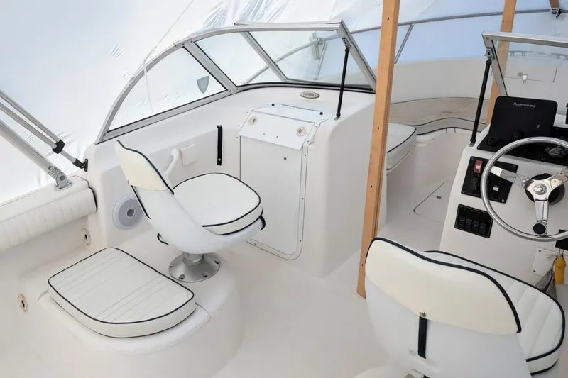 Slide: The Image of 2003 Palm Beach 22 Dual Console boat interior with white seating and steering wheel. - 8