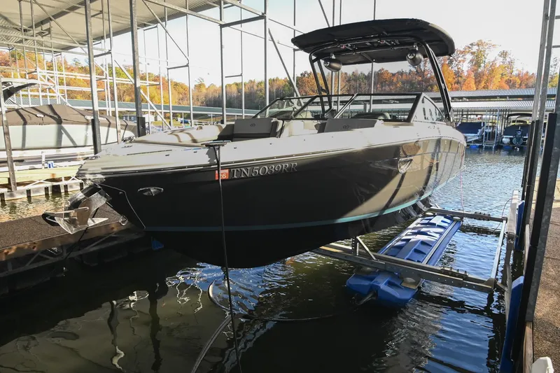 Slide: The Image of 2024 Cobalt R8 boat docked in a marina with autumn trees in the background. - 3