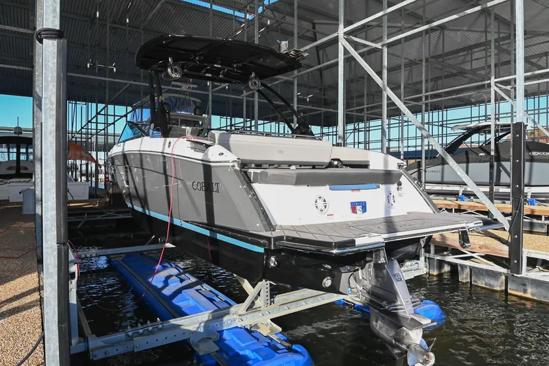 Slide: The Image of 2024 Cobalt R8 boat docked at marina with autumn trees in background. - 4