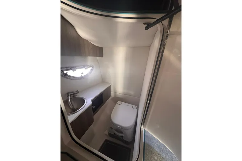 Slide: The Image of 2020 Regal LS6 boat bathroom with sink, toilet, and window. - 15