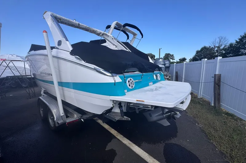 Slide: The Image of 2020 Regal LS6 boat on trailer under clear blue sky. - 2