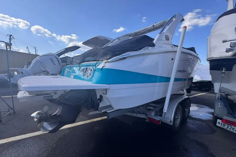 Slide: The Image of 2020 Regal LS6 boat on trailer, blue and white design, parked outdoors. - 3