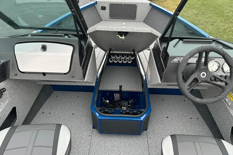 Slide: The Image of 2026 Lund 1675 Adventure Sport boat interior with steering wheel and storage compartments. - 6
