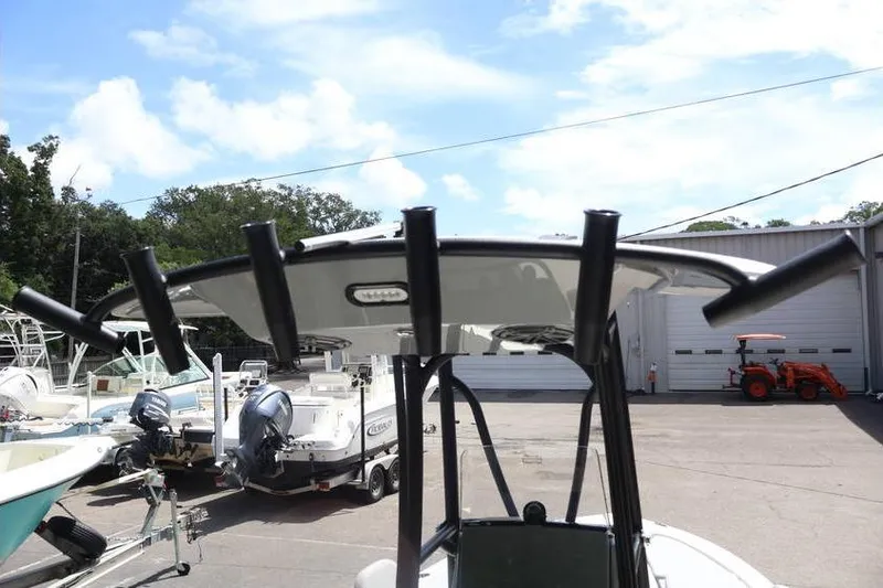 Slide: The Image of 2025 Pathfinder 2200 TRS boat with T-top and rod holders in a marina setting. - 21