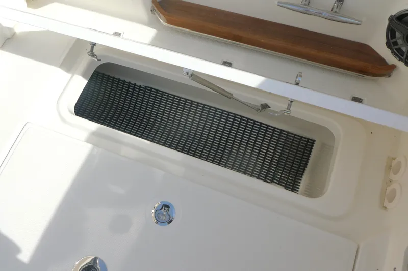 Slide: The Image of Storage compartment on 2026 Boston Whaler 380 Realm boat, featuring a secure latch and non-slip mat. - 12