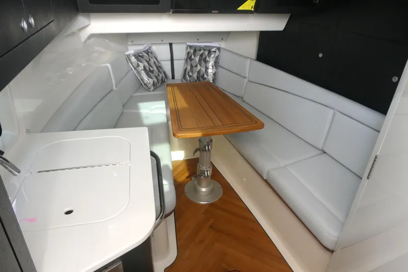 Slide: The Image of Interior of 2026 Boston Whaler 380 Realm with sleek seating and wooden table. - 16