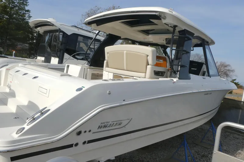 Slide: The Image of 2026 Boston Whaler 380 Realm boat, sleek design, white exterior, docked outdoors. - 2