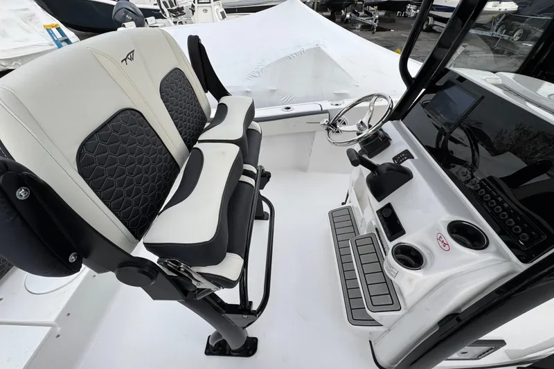 Slide: The Image of 2026 Tidewater 220 LXF boat interior with modern helm and cushioned seating. - 16
