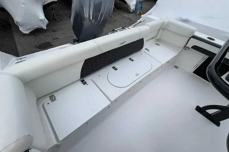 Slide: The Image of 2026 Tidewater 220 LXF boat interior with white seating and storage compartments. - 17
