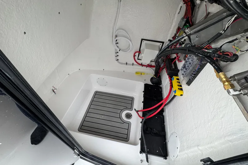 Slide: The Image of Interior view of 2026 Tidewater 220 LXF boat's electrical wiring and compartment. - 18