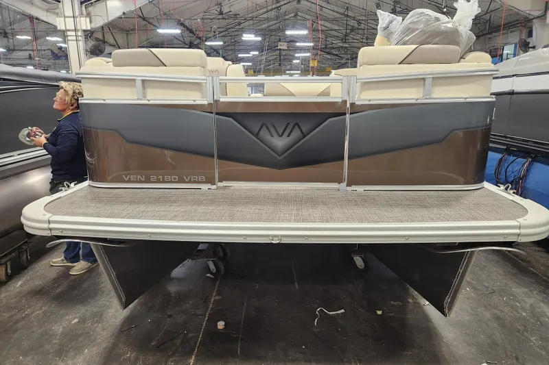 Slide: The Image of 2026 Avalon Venture Versatile Rear Bench pontoon boat in a factory setting. - 12