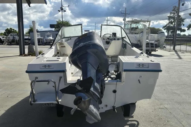 Slide: The Image of 1998 PROSPORT 20cc boat with outboard motor, parked in a marina under cloudy skies. - 3