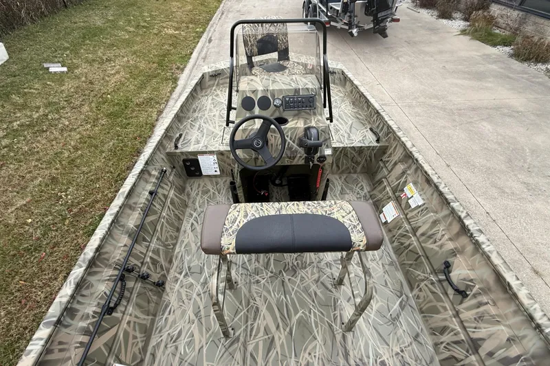 Slide: The Image of 2026 Crestliner 1870 Retriever FCC boat with camo design, parked on driveway. - 4