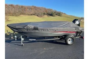 Slide: The Image of 2018 Tracker Super Guide V-16 SC boat covered on trailer, parked outdoors. - 6