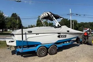 Slide: The Image of 2020 Axis A22 boat on trailer, covered, parked outdoors. - 2