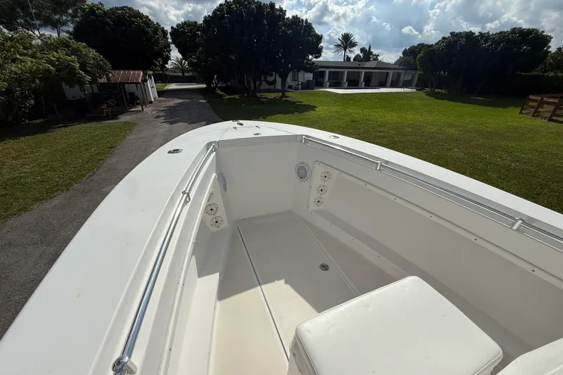 Slide: The Image of 2008 Contender 23 Open boat on driveway, surrounded by lush greenery and a house. - 17