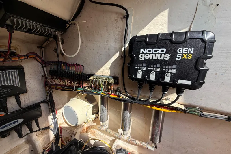 Slide: The Image of Electrical setup in a 2008 Contender 23 Open boat featuring a NOCO Genius GEN 5X3 charger. - 23