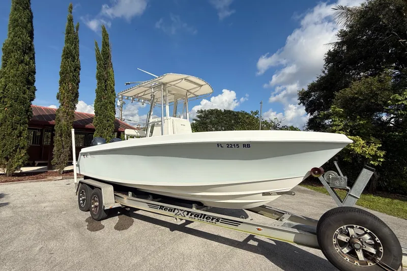 Slide: The Image of 2008 Contender 23 Open boat on trailer, parked outdoors under a clear blue sky. - 3