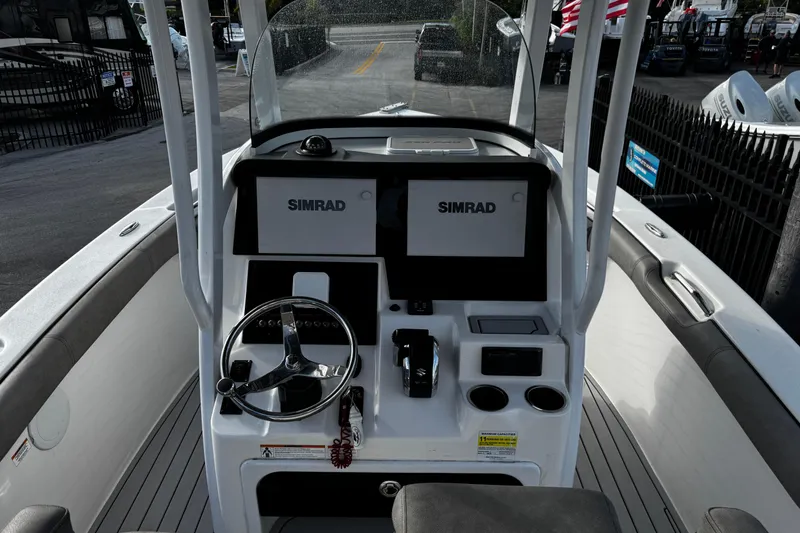 Slide: The Image of 2022 Sea Pro 239 Center Console boat interior with dual Simrad displays and steering wheel. - 17