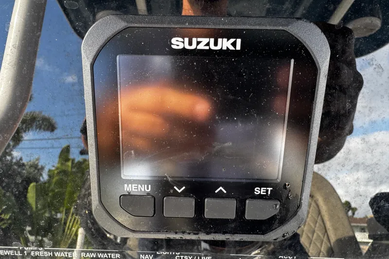 Slide: The Image of Suzuki display on 2022 Sea Pro 239 Center Console boat, reflecting outdoor scenery. - 25