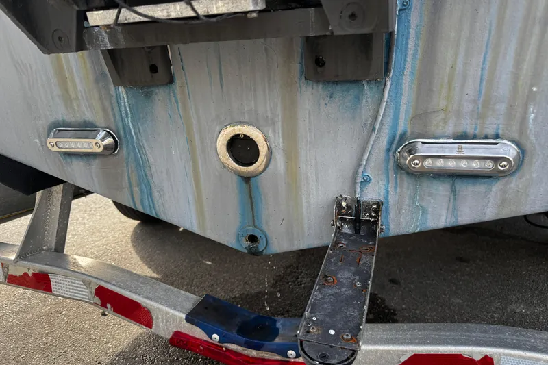 Slide: The Image of 2022 Sea Pro 239 Center Console boat stern with trailer, showing wear and LED lights. - 5