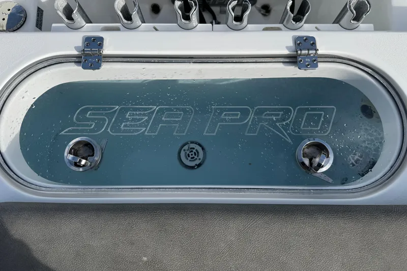 Slide: The Image of 2022 Sea Pro 239 Center Console livewell with rod holders and water droplets. - 8