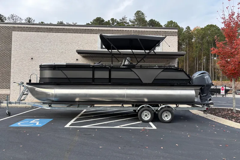 The Image of 2026 Veranda Relax VR 235 VLI pontoon boat on trailer, parked near a building. - 1