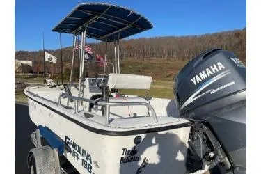 Slide: The Image of 2006 Carolina Skiff 198 DLX boat with Yamaha outboard motor, parked outdoors. - 4
