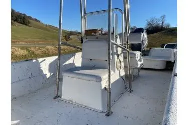 Slide: The Image of 2006 Carolina Skiff 198 DLX boat interior with seating and console, set in a rural landscape. - 7