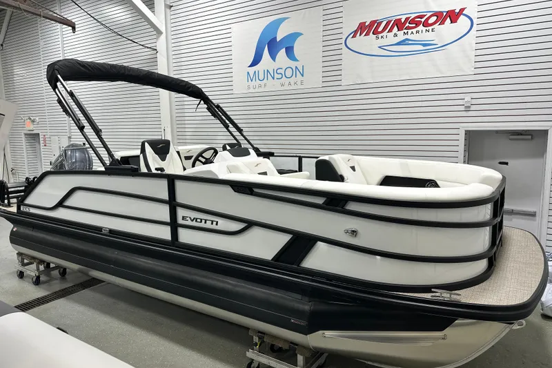 Slide: The Image of 2026 Evotti 521CS pontoon boat in showroom, Munson Ski & Marine signage visible. - 0