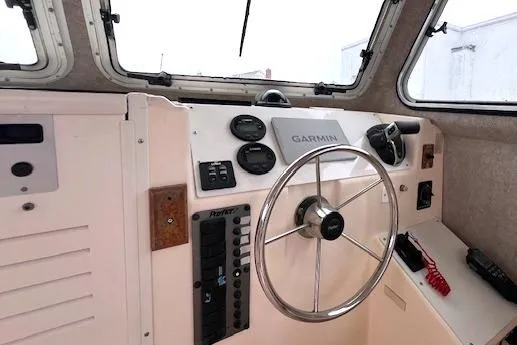 Slide: The Image of 2005 Parker 2320 SL Sport Cabin helm with Garmin navigation and steering wheel. - 7