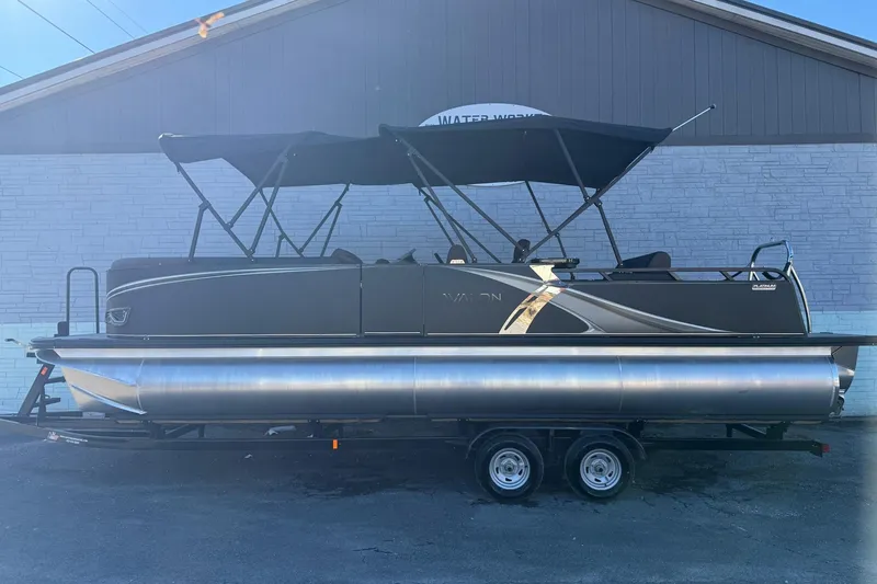 The Image of 2026 Avalon 2585 LSZ Entertainer pontoon boat on trailer, parked outdoors. - 1