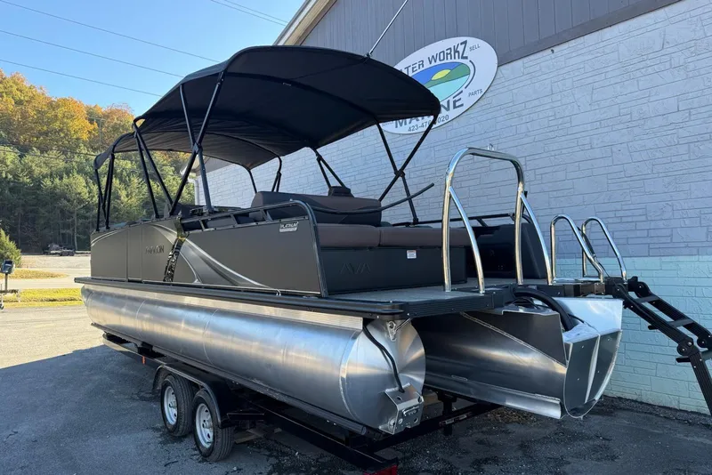 Slide: The Image of 2026 Avalon 2585 LSZ Entertainer pontoon boat with canopy on trailer, parked outdoors. - 4