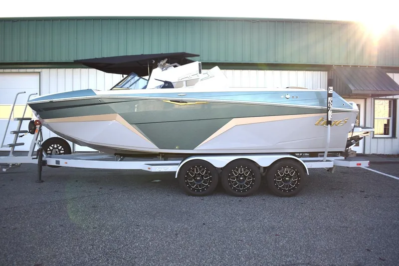 Slide: The Image of 2026 Tigé Z3 boat on trailer, parked outdoors with sunlight in background. - 2