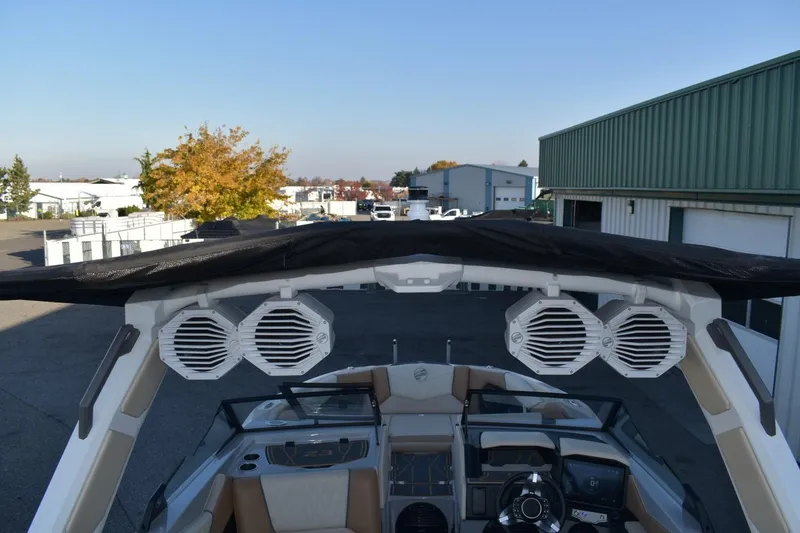 Slide: The Image of 2026 Tigé Z3 boat with speakers and canopy in a parking area. - 74