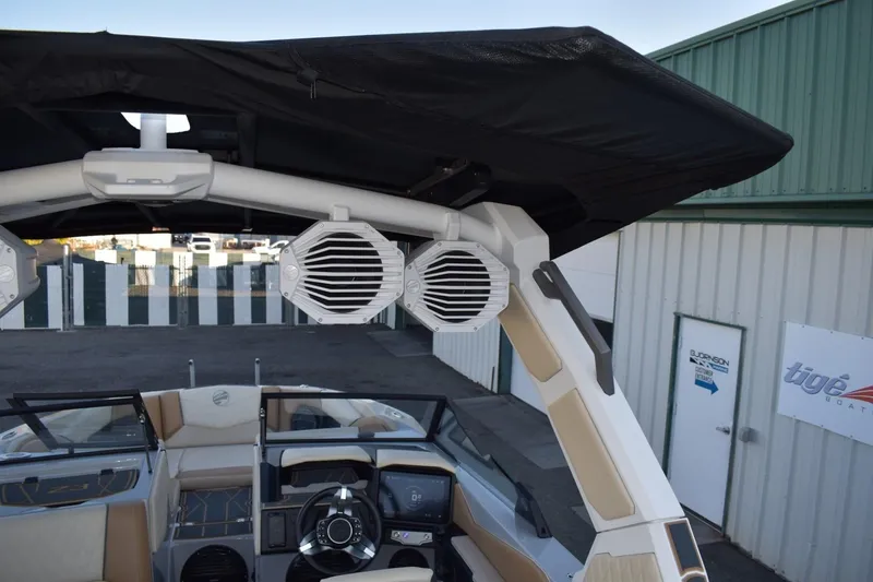 Slide: The Image of 2026 Tigé Z3 boat interior with speakers and steering wheel, docked near a building. - 76