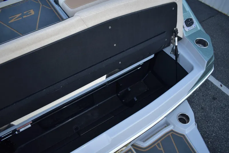 Slide: The Image of 2026 Tigé Z3 boat storage compartment with open lid and cup holders. - 81