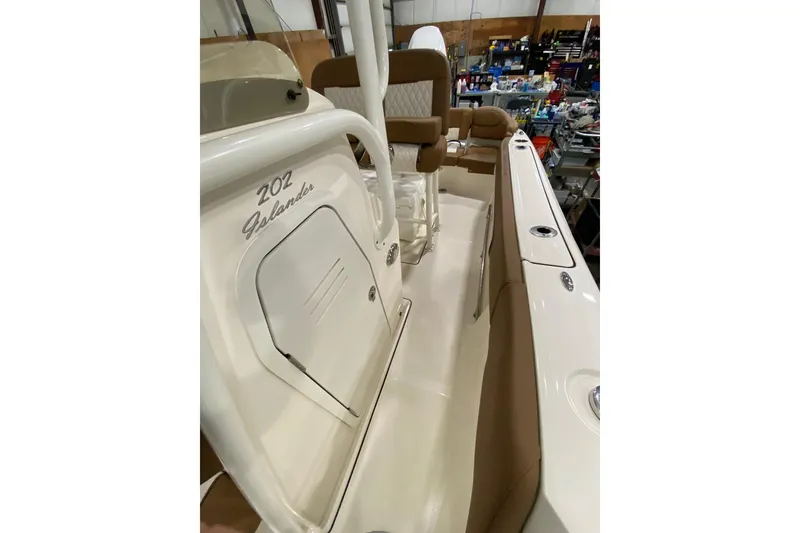 Slide: The Image of 2024 Pioneer 202 Islander boat interior with brown seating and white accents. - 11