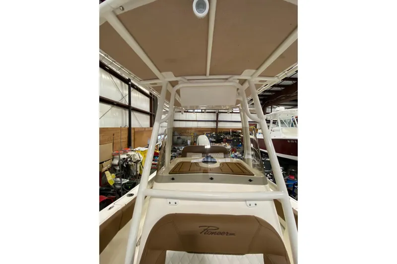 Slide: The Image of 2024 Pioneer 202 Islander boat interior with tan seating and storage compartment. - 12