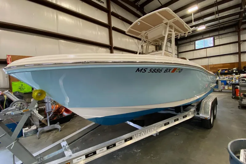 Slide: The Image of 2024 Pioneer 202 Islander boat with Suzuki outboard motor in a warehouse setting. - 3