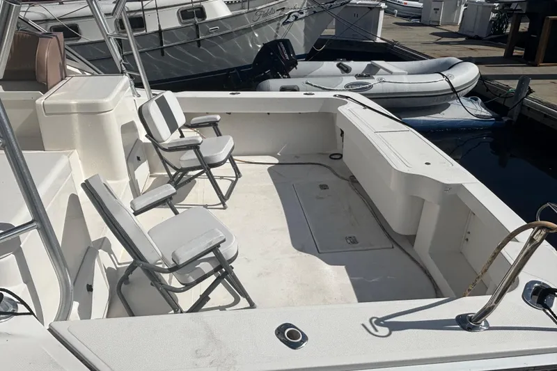 Slide: The Image of 2004 Luhrs 32 Open boat deck with chairs, docked beside inflatable boat. - 12