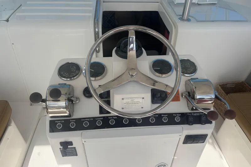 Slide: The Image of 2004 Luhrs 32 Open helm with steering wheel, gauges, and controls. - 19