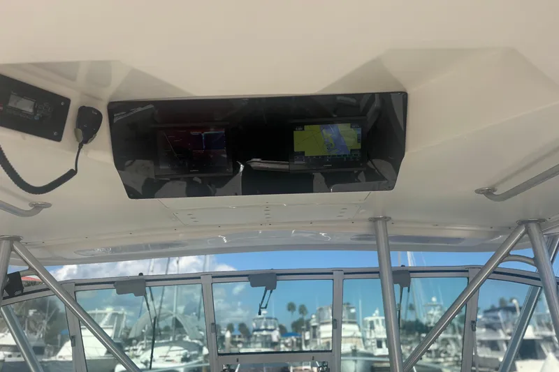 Slide: The Image of 2004 Luhrs 32 Open boat cockpit with navigation equipment and marina view. - 20